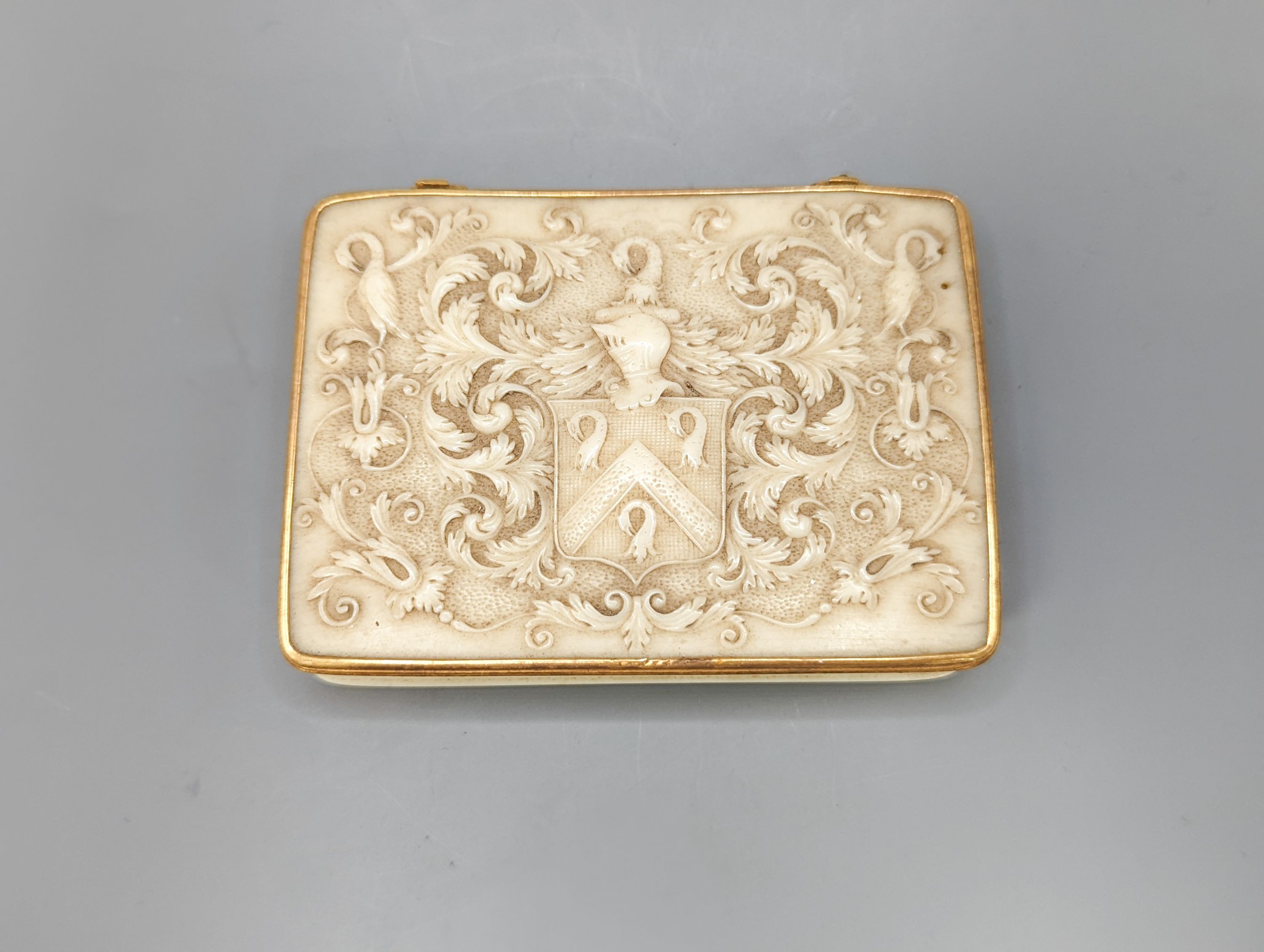 An early 19th century gold mounted ivory armorial table snuff box, 8.3 cm